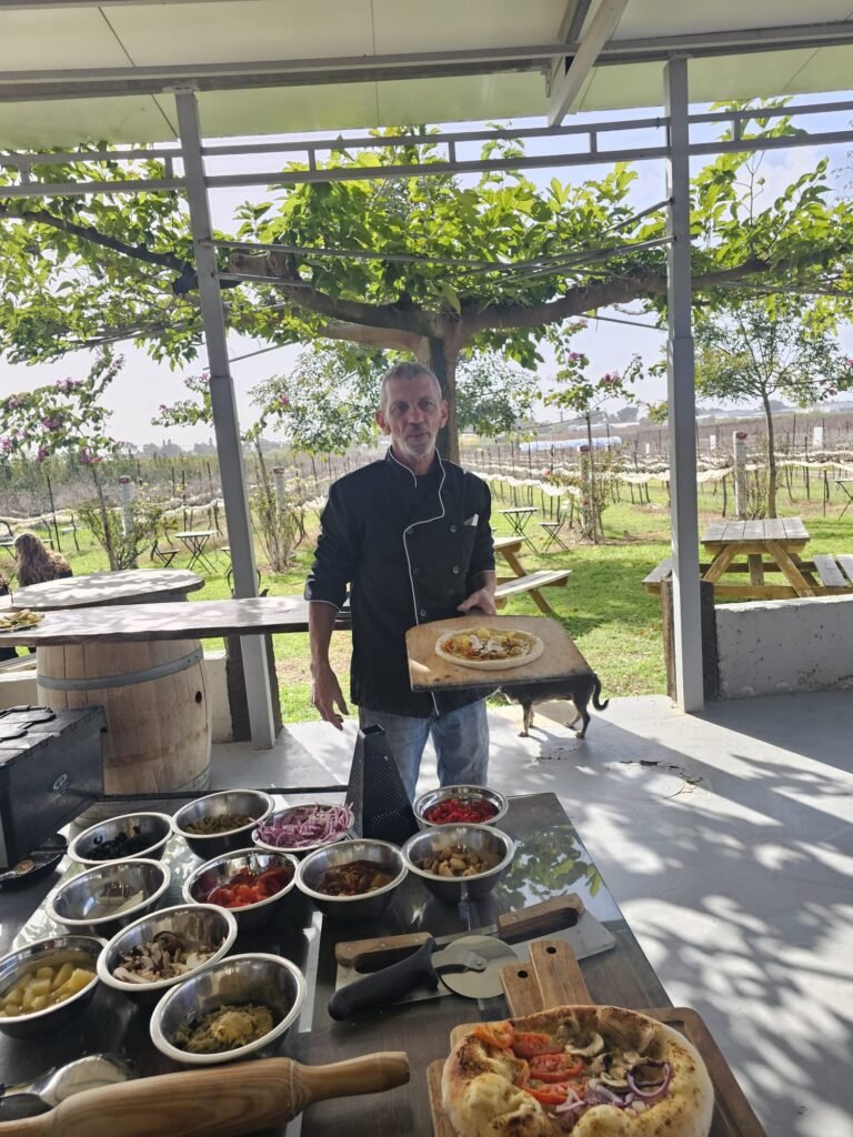 השף מגיש פוקצ'ה ליד שולחן שוק באירוע בגינה